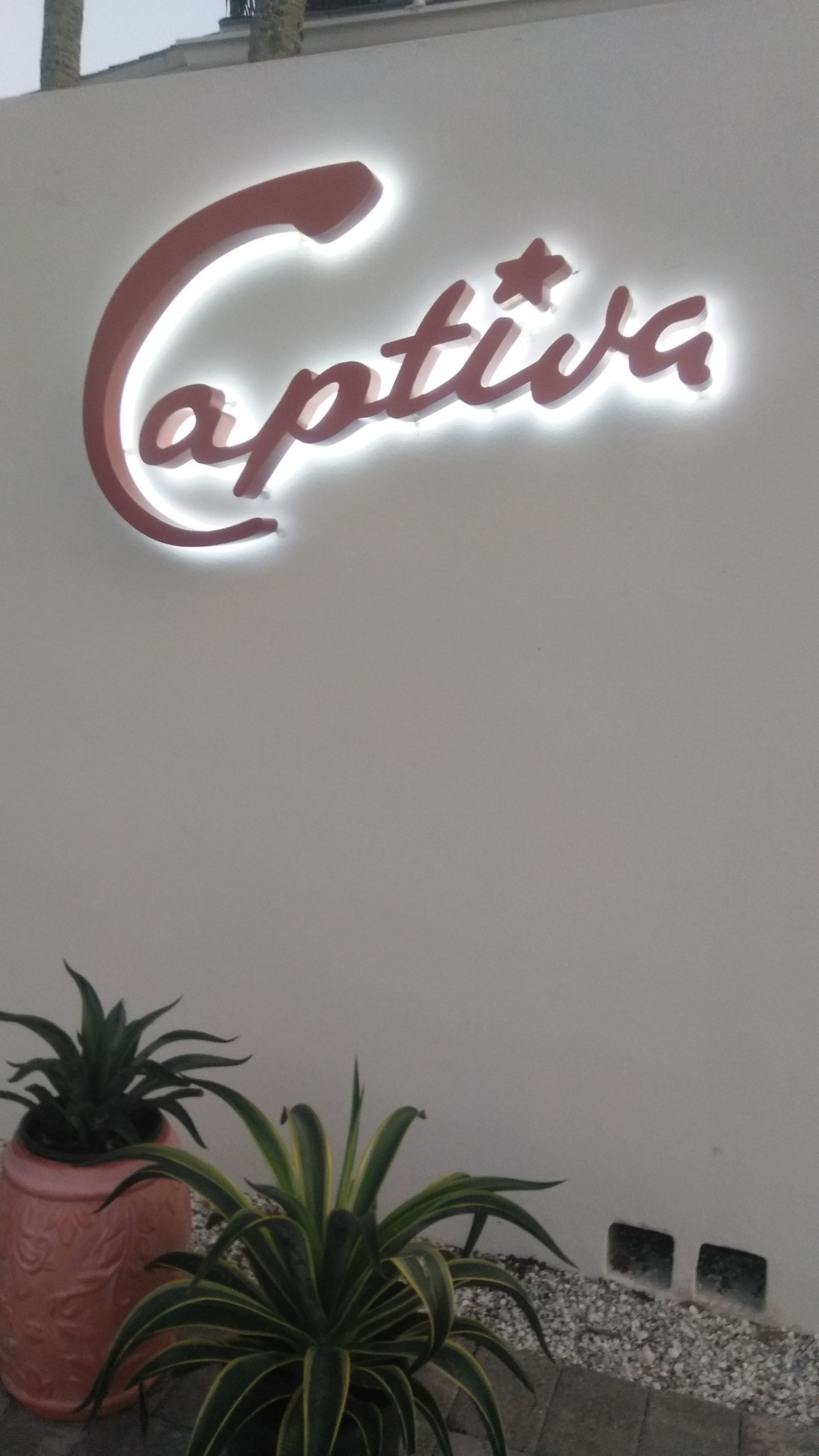 Eine Wand, auf der der Schriftzug „Captiva“ in einer stilisierten Schrift beleuchtet ist.