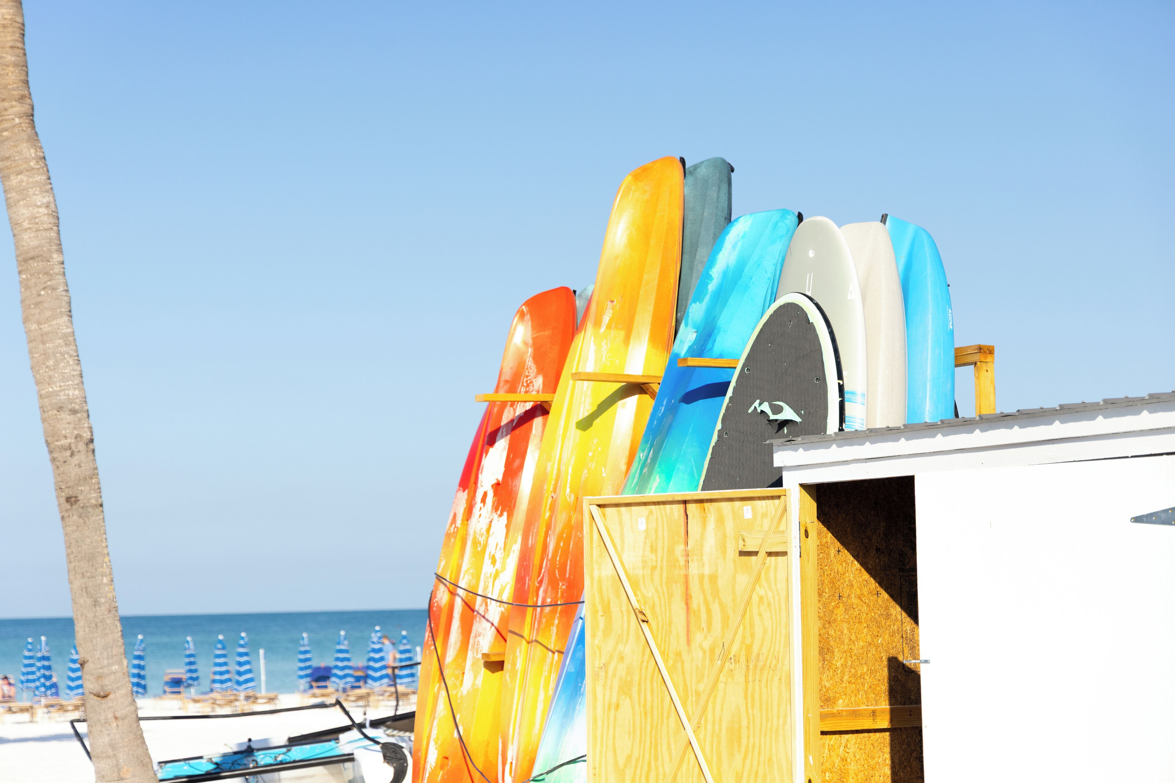 A wooden structure with colorful kayaks stored inside.