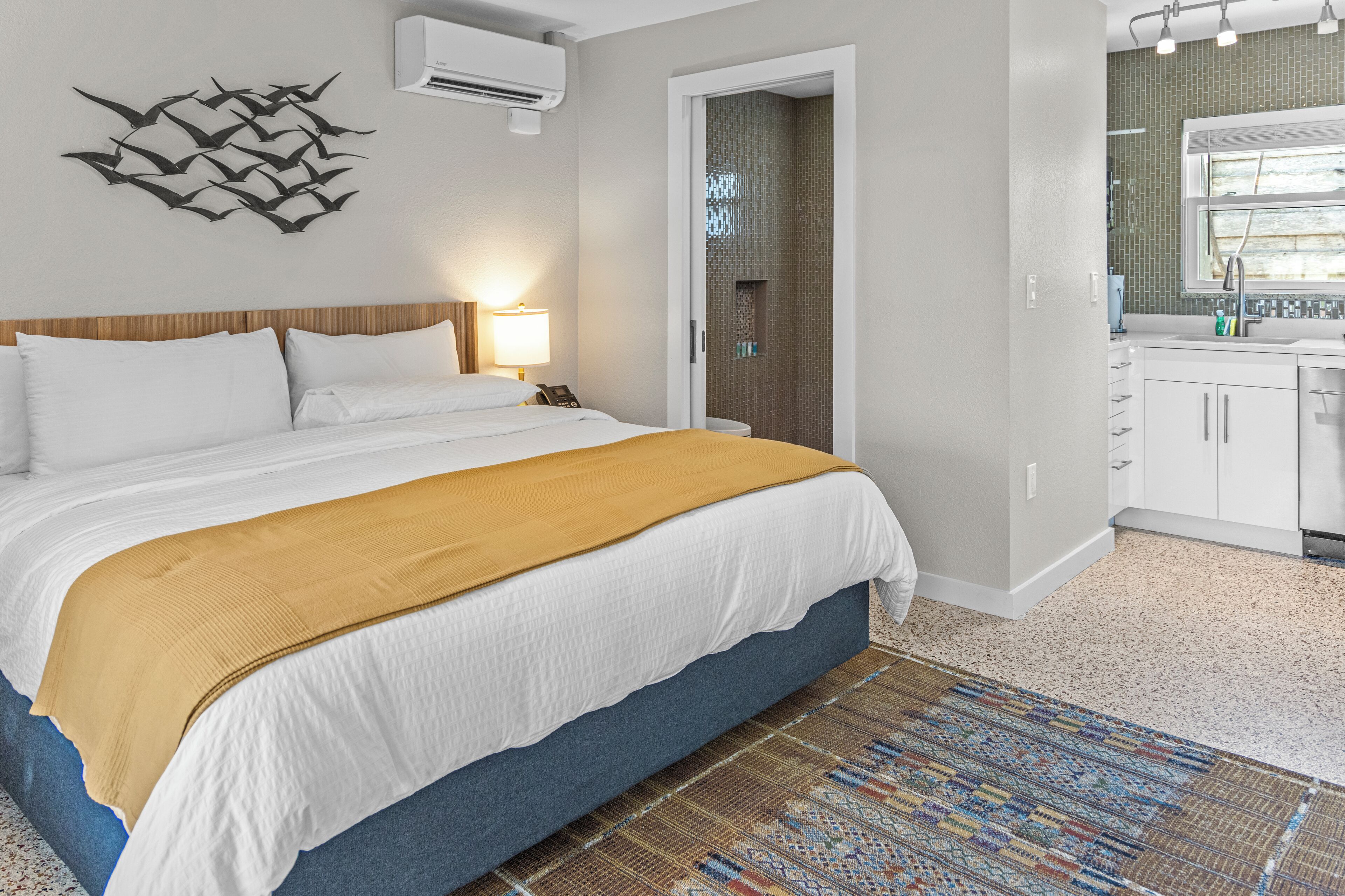 Una camera da letto con un letto, un comodino e un condizionatore d'aria a parete.
