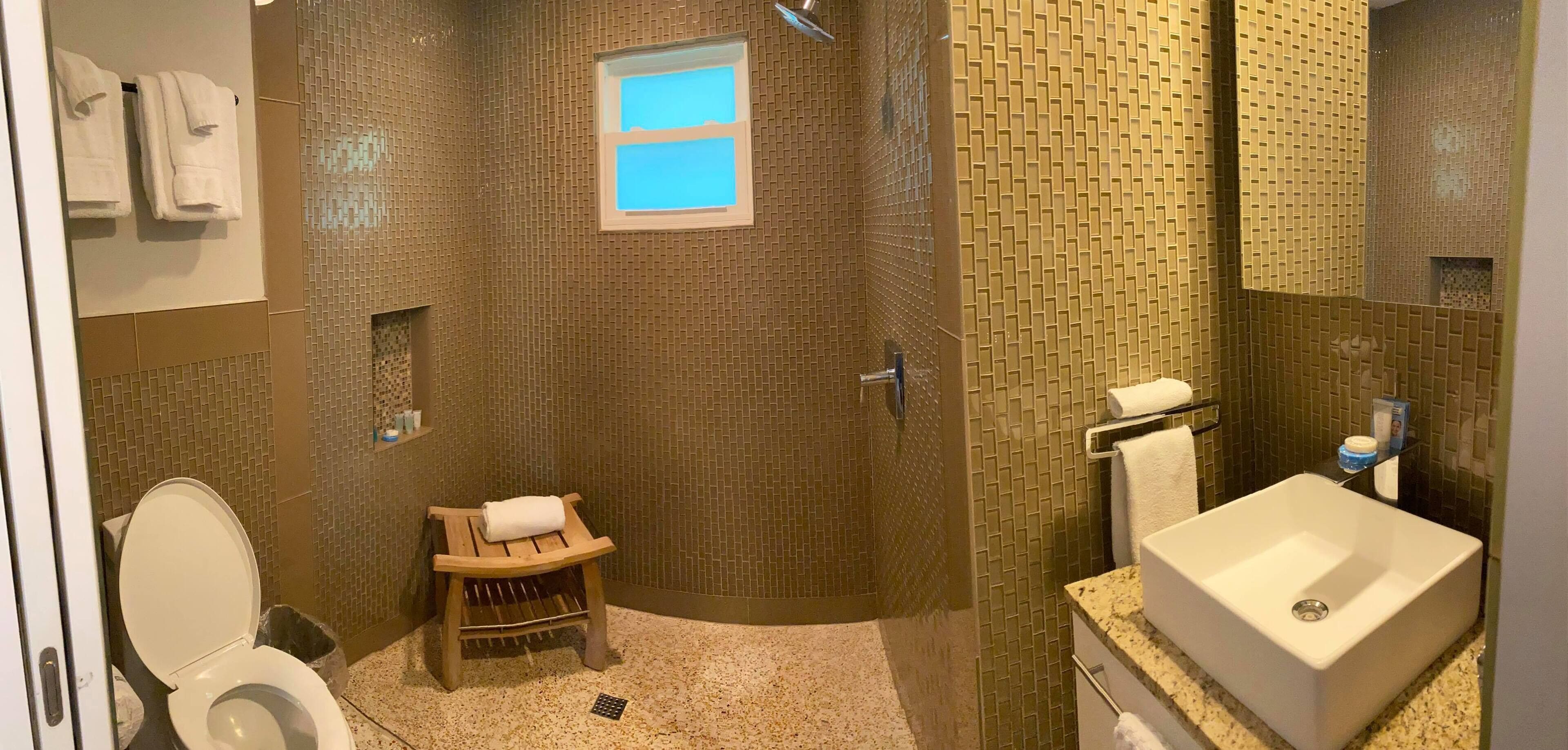 Ein Badezimmer mit Dusche, Toilette und Waschbecken.