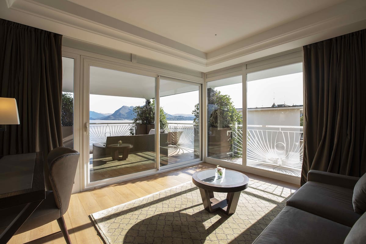 Ein modernes Zimmer mit Balkon, einem runden Tisch und einer Couch.