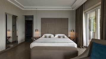A modern hotel room with a large bed, a seating area, and a view of the outdoors.