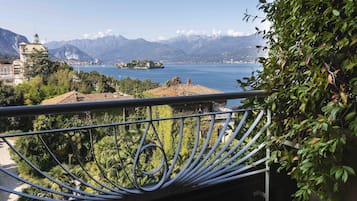 A balcony with a view of a lake, mountains, and a distant island.