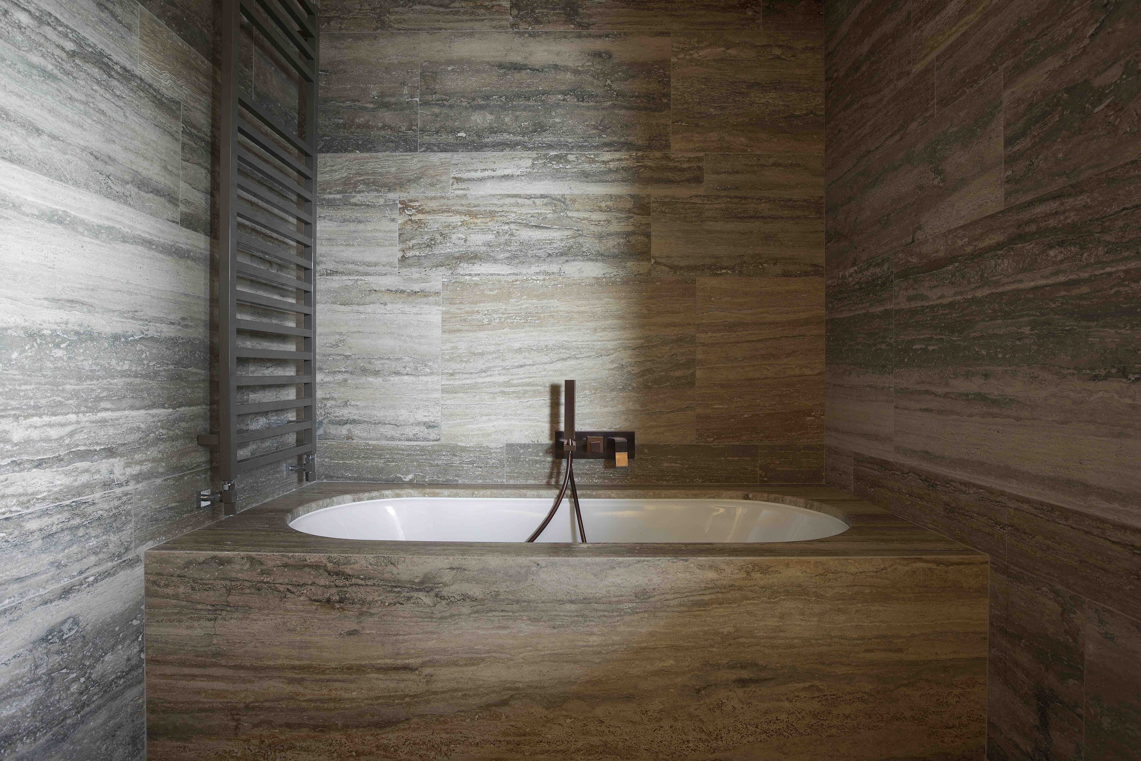 A modern bathroom with a freestanding bathtub, a wooden vanity, and a built-in shower area.