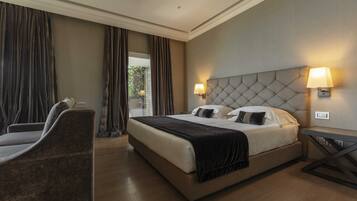 A hotel room with a large bed, two bedside lamps, a chair, and a view of greenery outside.