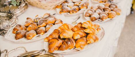 A buffet table with various pastries and desserts.