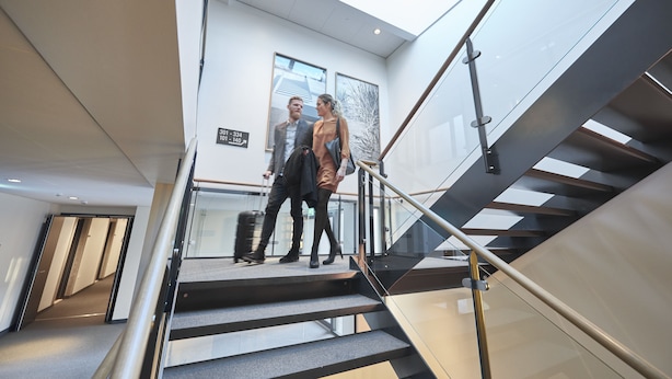 A modern hotel interior with a staircase, glass railings, and a high ceiling with skylights. - Four Points Flex by Sheraton Copenhagen Airport (Kastrup)
