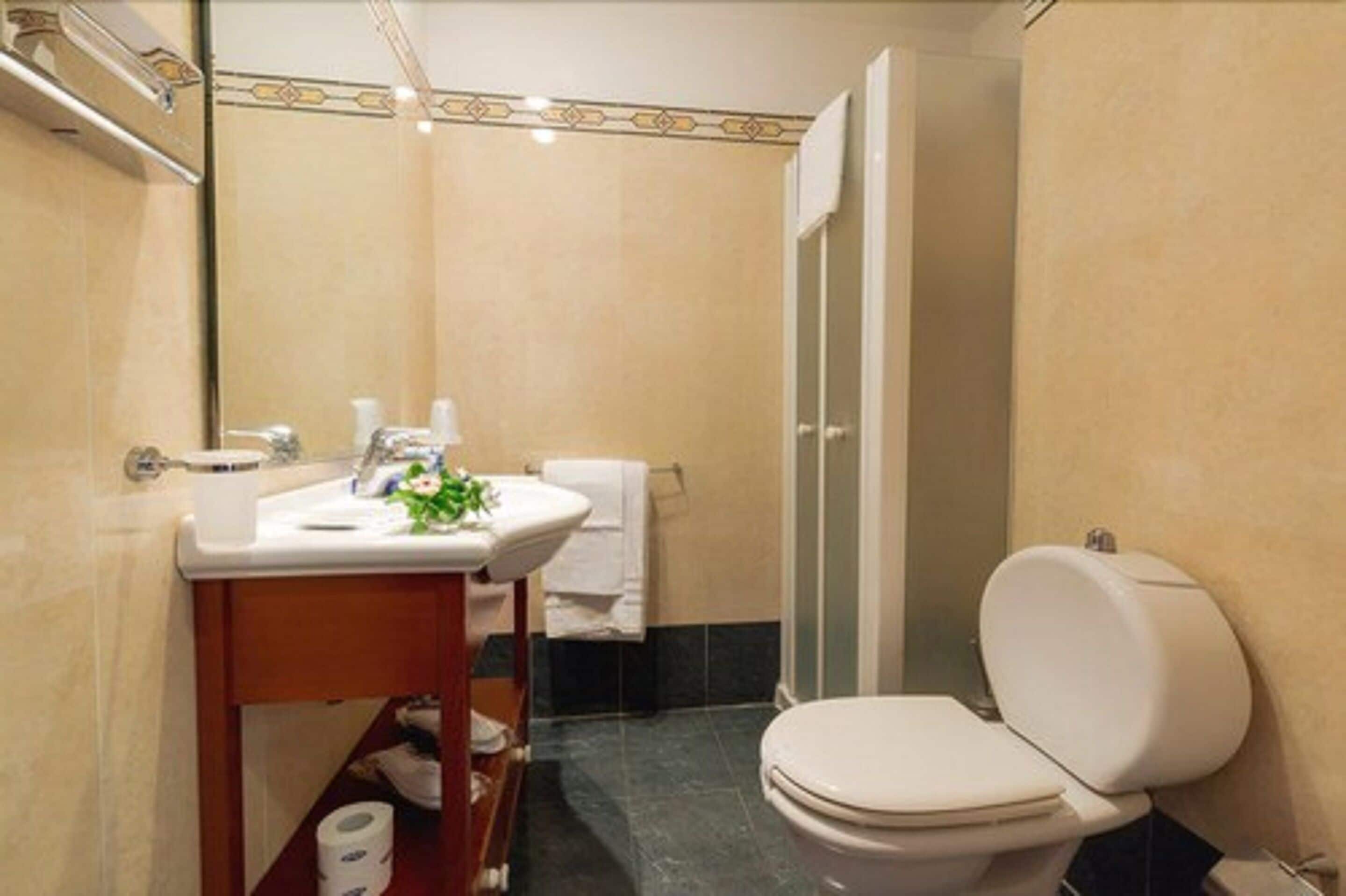 A bathroom with a toilet, sink, and shower.