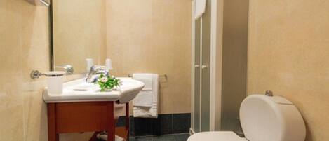 A bathroom with a toilet, sink, and shower.