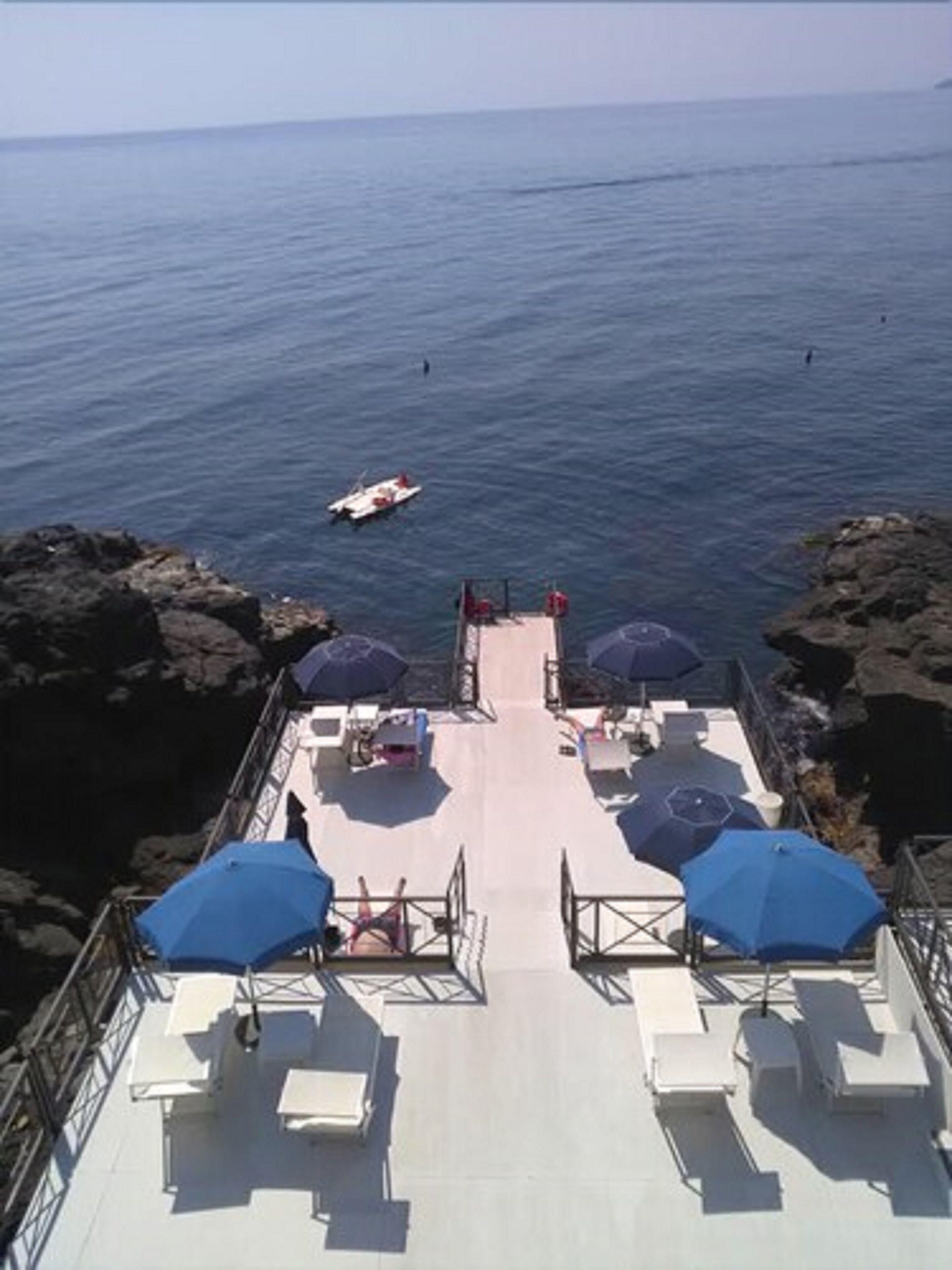 Una terraza con asientos al aire libre y sombrillas con vistas al mar.