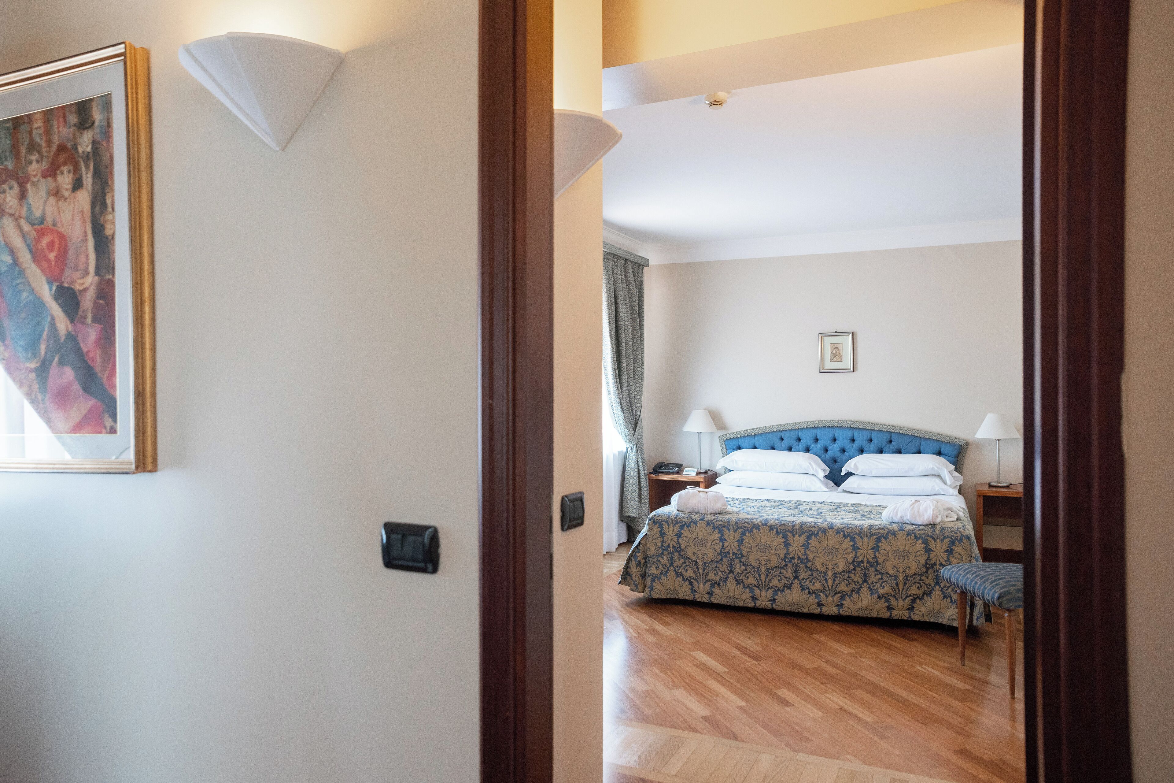 Una camera da letto con un letto, comodini e un quadro appeso al muro.