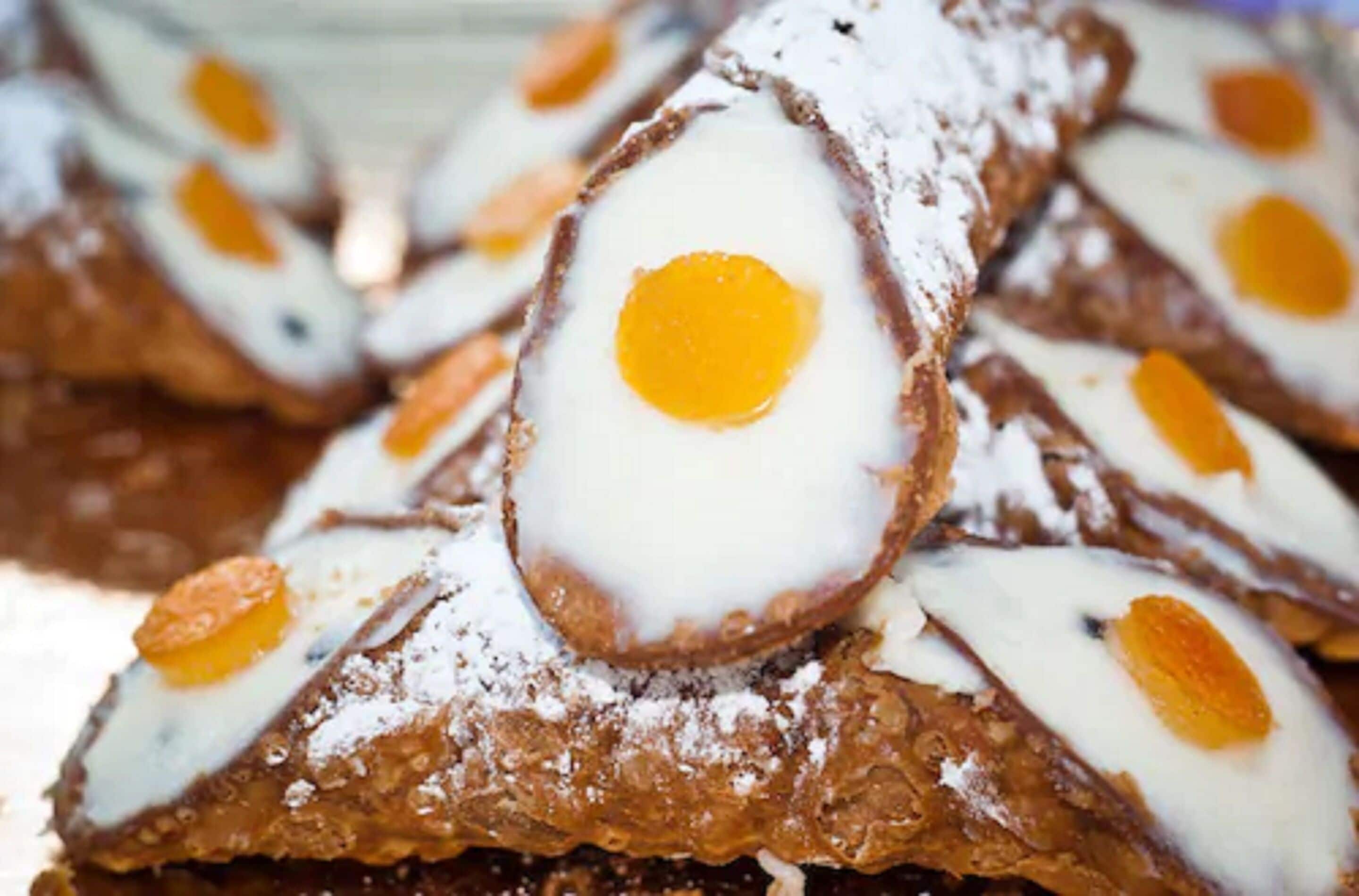 Ein Detailaufnahme eines Desserts mit cremiger Füllung und einer Zuckerpuder-Glasur.