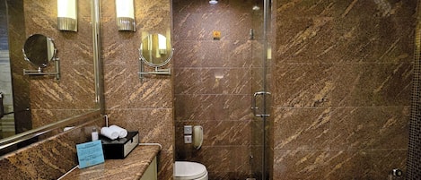 A modern bathroom with a marble vanity, a separate toilet, a glass-enclosed shower, and a separate bathtub.