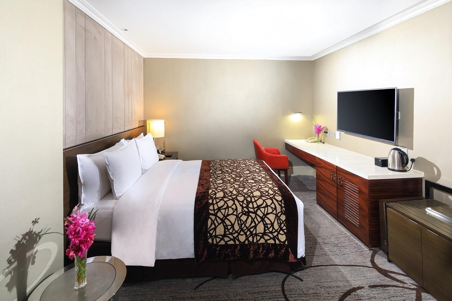 Una habitación de hotel con una cama, un escritorio, un televisor y una cafetera.