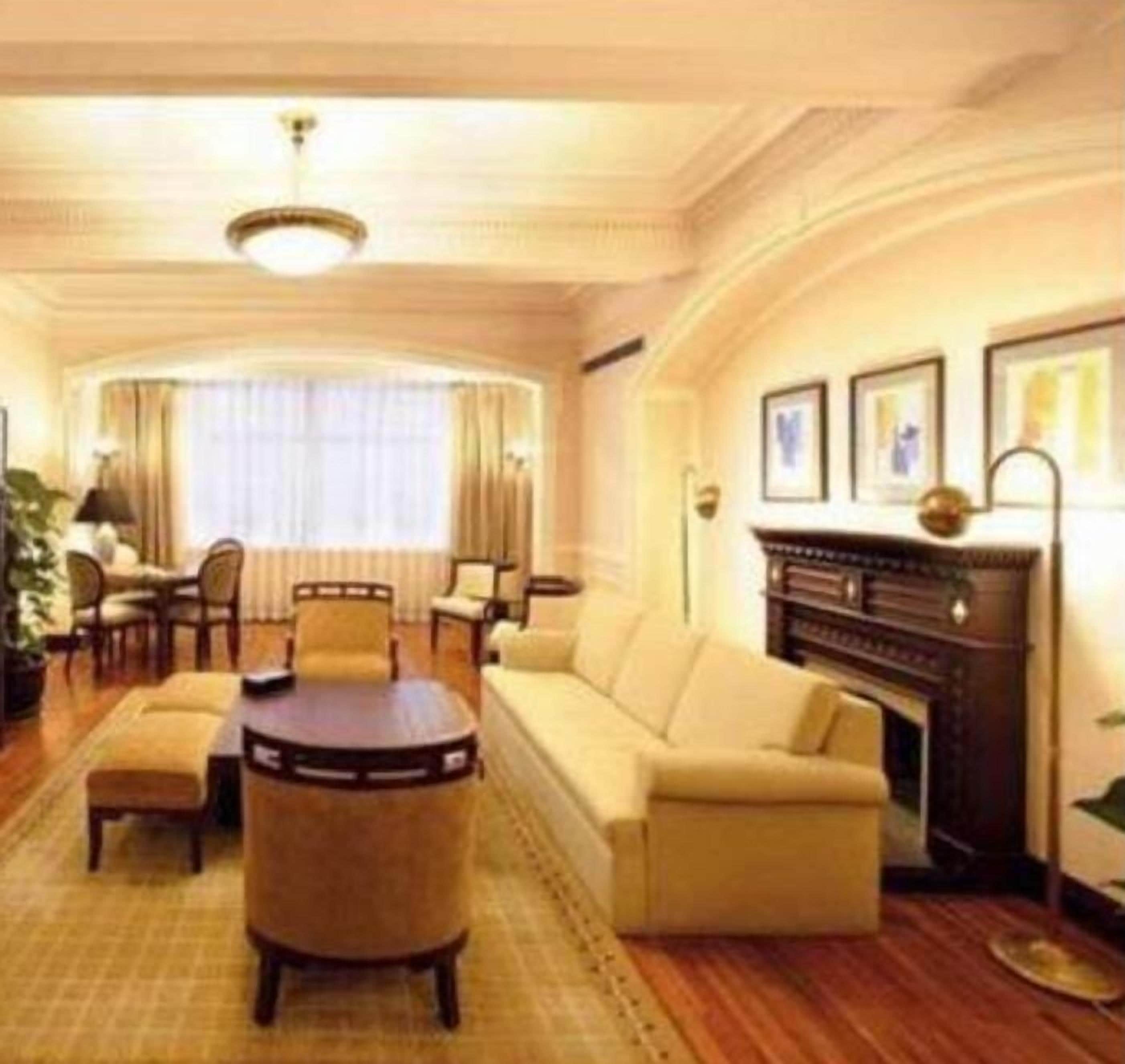 A spacious living room with a sofa set, a coffee table, and a fireplace.
