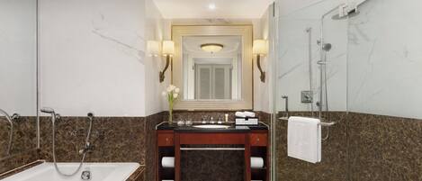 A modern bathroom with a bathtub, vanity, and shower.