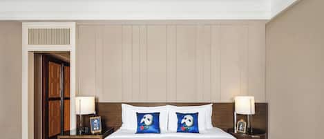 A hotel room with a bed, two nightstands, a dresser, and a door.