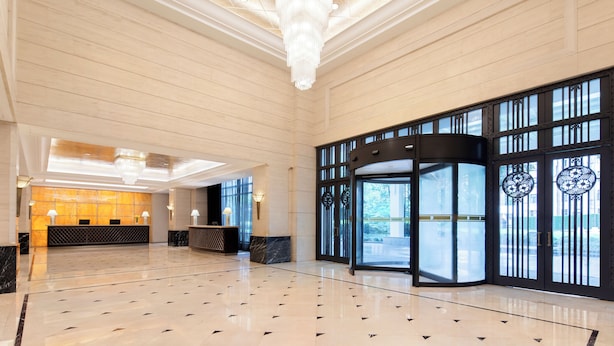 A spacious lobby with a marble floor, a reception desk, and a large chandelier. - Jin Jiang Hotel Shanghai (Shanghai)