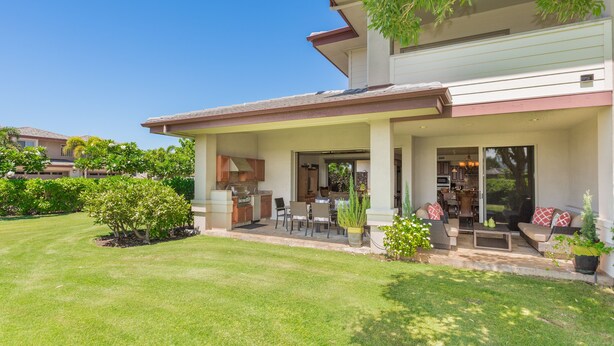 A two-story house with a covered patio, a kitchen, and a dining area. - Villages at Mauna Lani (Kamuela)