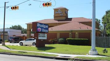 Hotel Budget Inn con un letrero, un cartel de estacionamiento y un semáforo.
