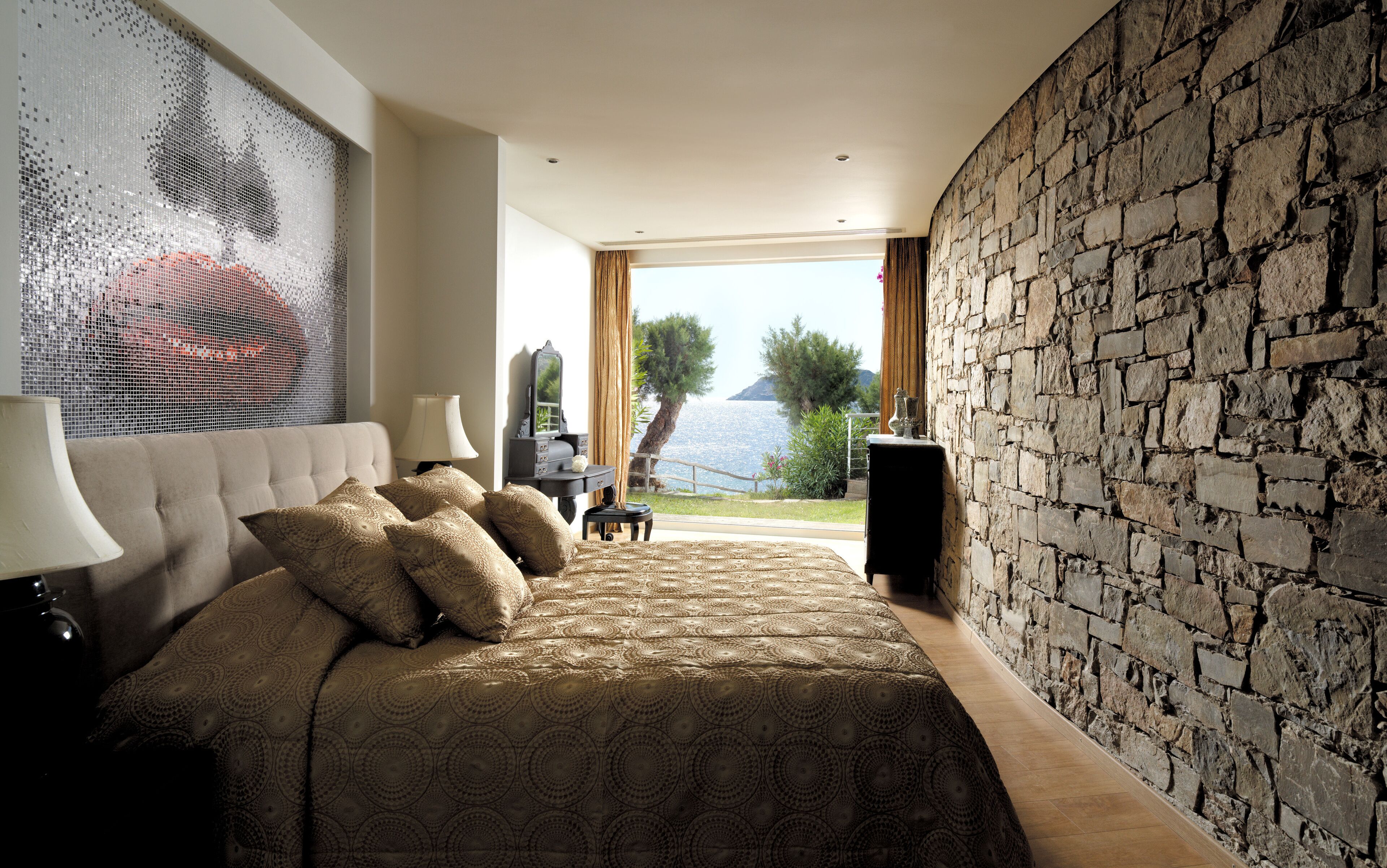 Una camera da letto con un letto grande, uno specchio, un comò e vista mare.