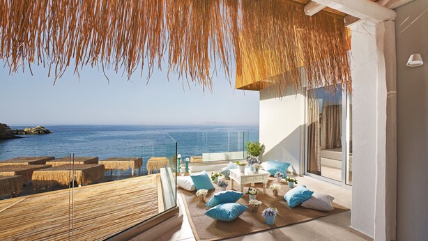 A balcony with a view of the sea, furnished with cushions and a table. - Out Of The Blue All Inclusive Resort & Spa (Malevizi)