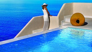 A woman in a white dress and hat standing by a pool with a view of the ocean. - Out Of The Blue All Inclusive Resort & Spa (Malevizi)