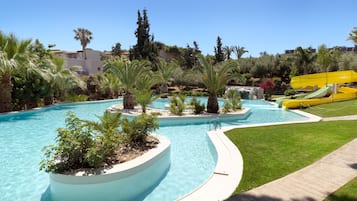 Relax by the resort pool surrounded by lush greenery and palm trees, with a water slide for fun.