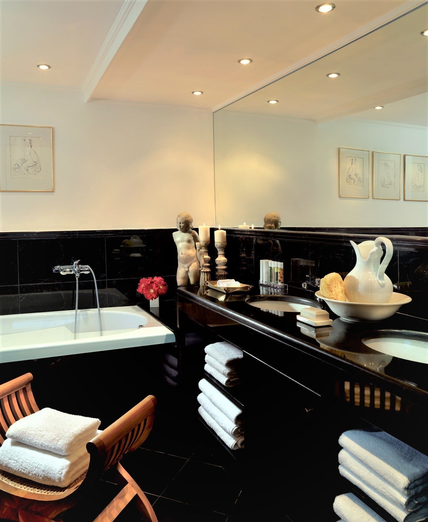 Un baño moderno con un espejo grande, una bañera y un tocador con lavabo y encimera.