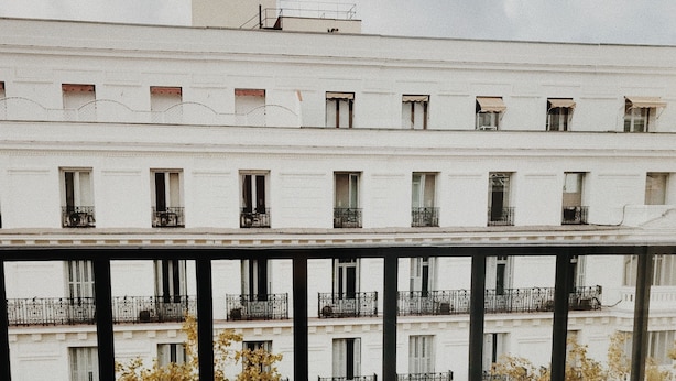 Una mesa con comida y bebidas en un balcón con vistas a un paisaje urbano.