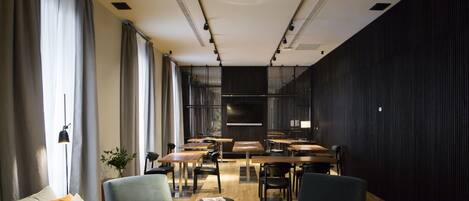 Un interior moderno con comedor, sofás y una planta.