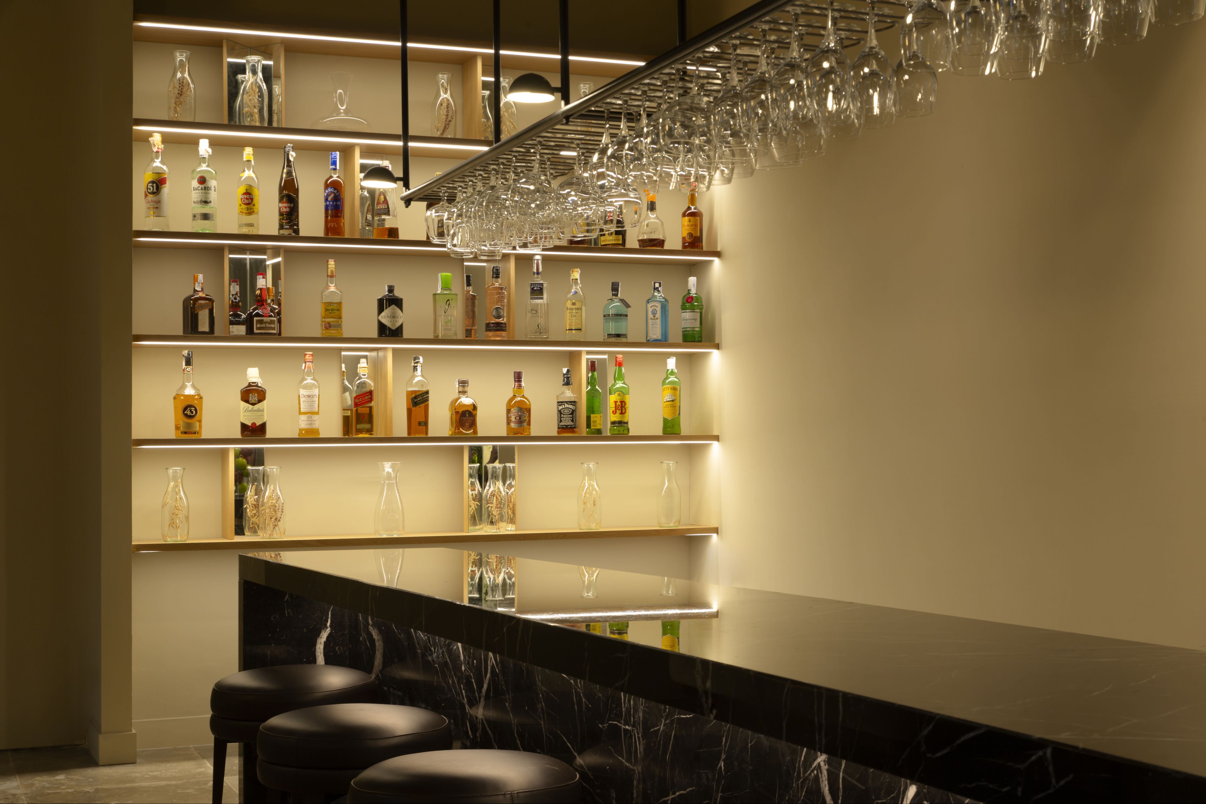 A bar area with shelves of liquor bottles and glasses.