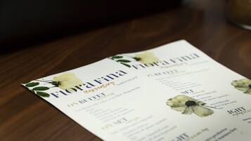 Eine Speisekarte mit floralen Elementen und Text, vermutlich für ein Restaurant oder Café.