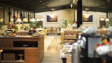 Ein moderner Hotel-Speiseraum mit Holzkubaturen, einem Buffet und Kunstwerken an den Wänden.