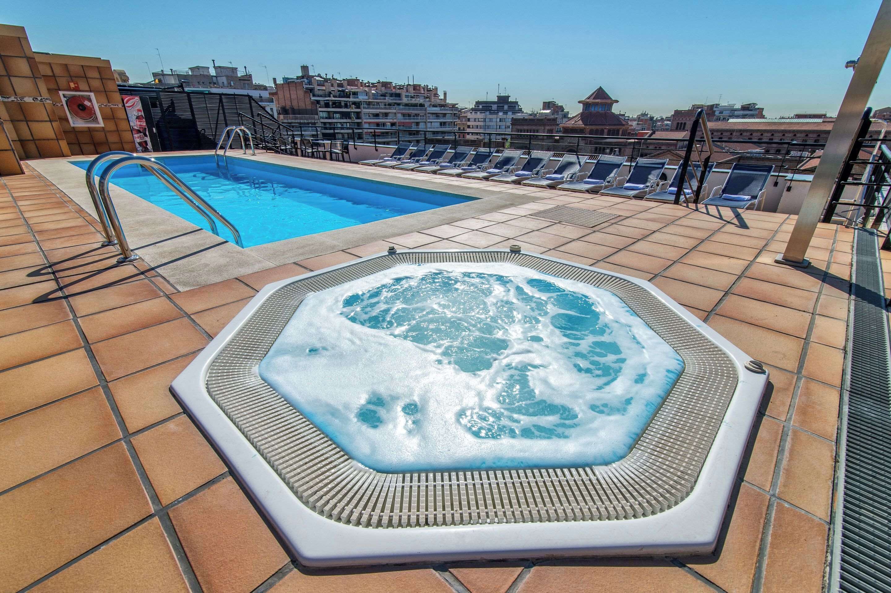 Een buitenzwembad, ligstoelen bij het zwembad