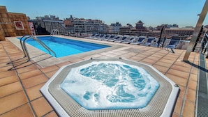 A rooftop pool area with a hot tub and lounge chairs. - Sunotel Junior (Barcelona)