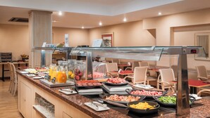 A buffet with various food options, a glass display case, and seating areas. - Petit Palace Junior formerly known as Sunotel Junior (Barcelona)