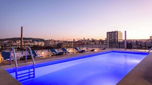 A rooftop pool with lounge chairs and a cityscape view. - Petit Palace Junior formerly known as Sunotel Junior (Barcelona)