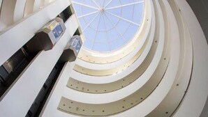En atriumgård med flere etager, et centralt ovenlys og en spiraltrappe.