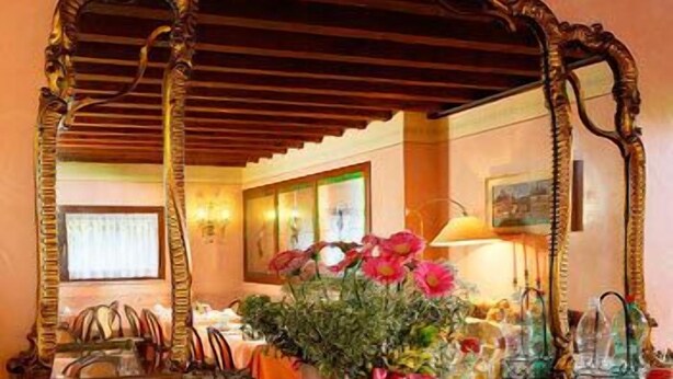 A breakfast buffet with various food items and a mirror reflecting the room. - Hotel Antico Moro (Mestre)