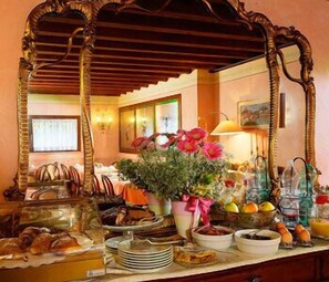 A breakfast buffet with various food items and a mirror reflecting the room. - Hotel Antico Moro (Mestre)