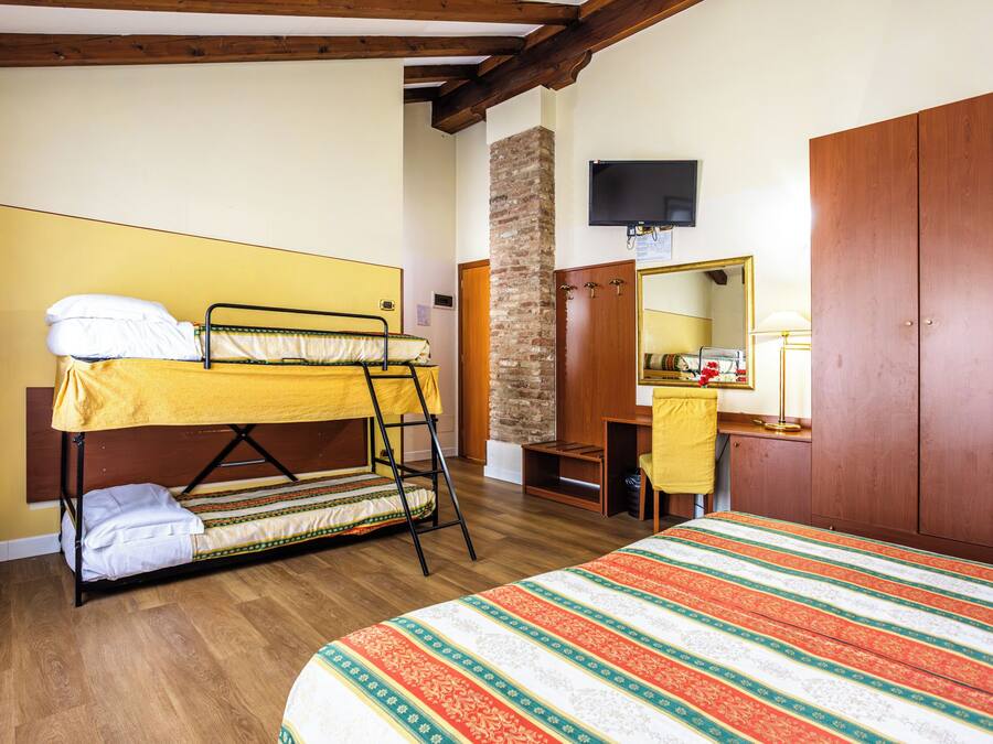 Quarto com beliche, guarda-roupa de madeira, escrivaninha com cadeira e espelho.