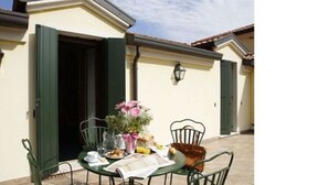 An outdoor dining area with a table set for two, a chair, and a potted plant. - Hotel Antico Moro (Mestre)