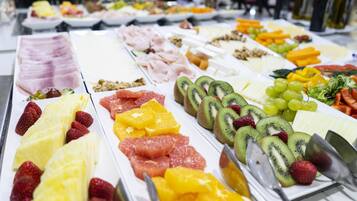 Un bufé con diversas frutas y quesos.