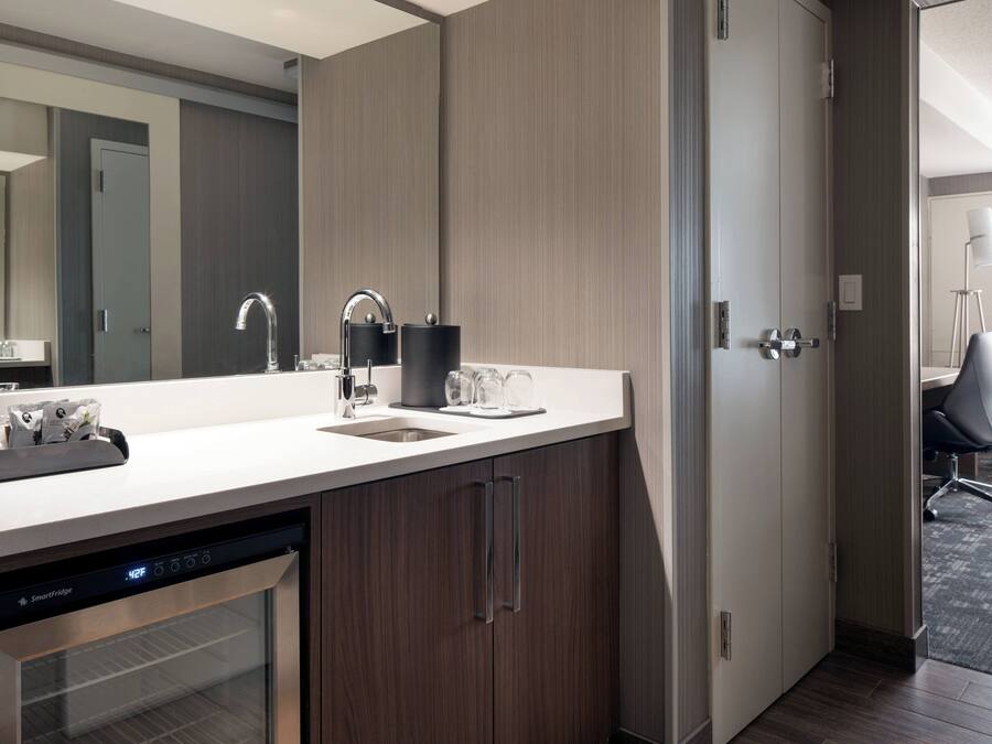Una cocina moderna con lavavajillas, un lavabo y una encimera con cafetera.