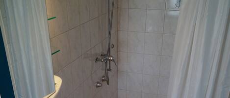 Ein Badezimmer mit Waschbecken, Spiegel, Dusche und Handtuchhalter.
