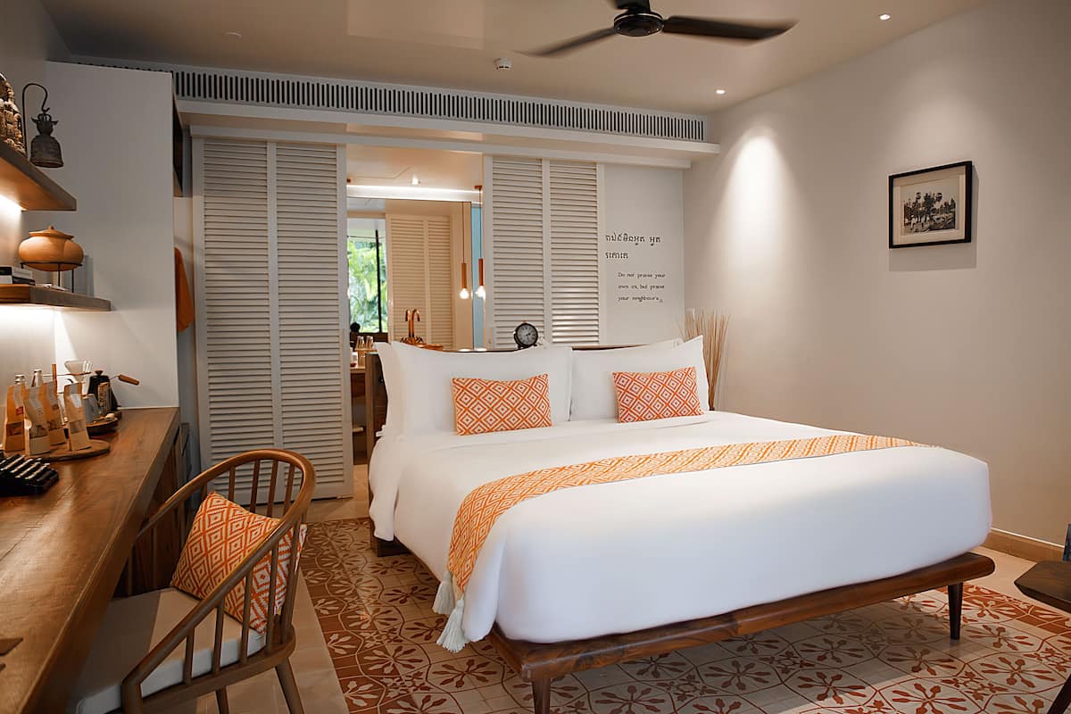 A hotel room with a bed, a desk, and a chair.