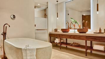 A modern bathroom with a freestanding bathtub, a wooden vanity, and a large mirror.
