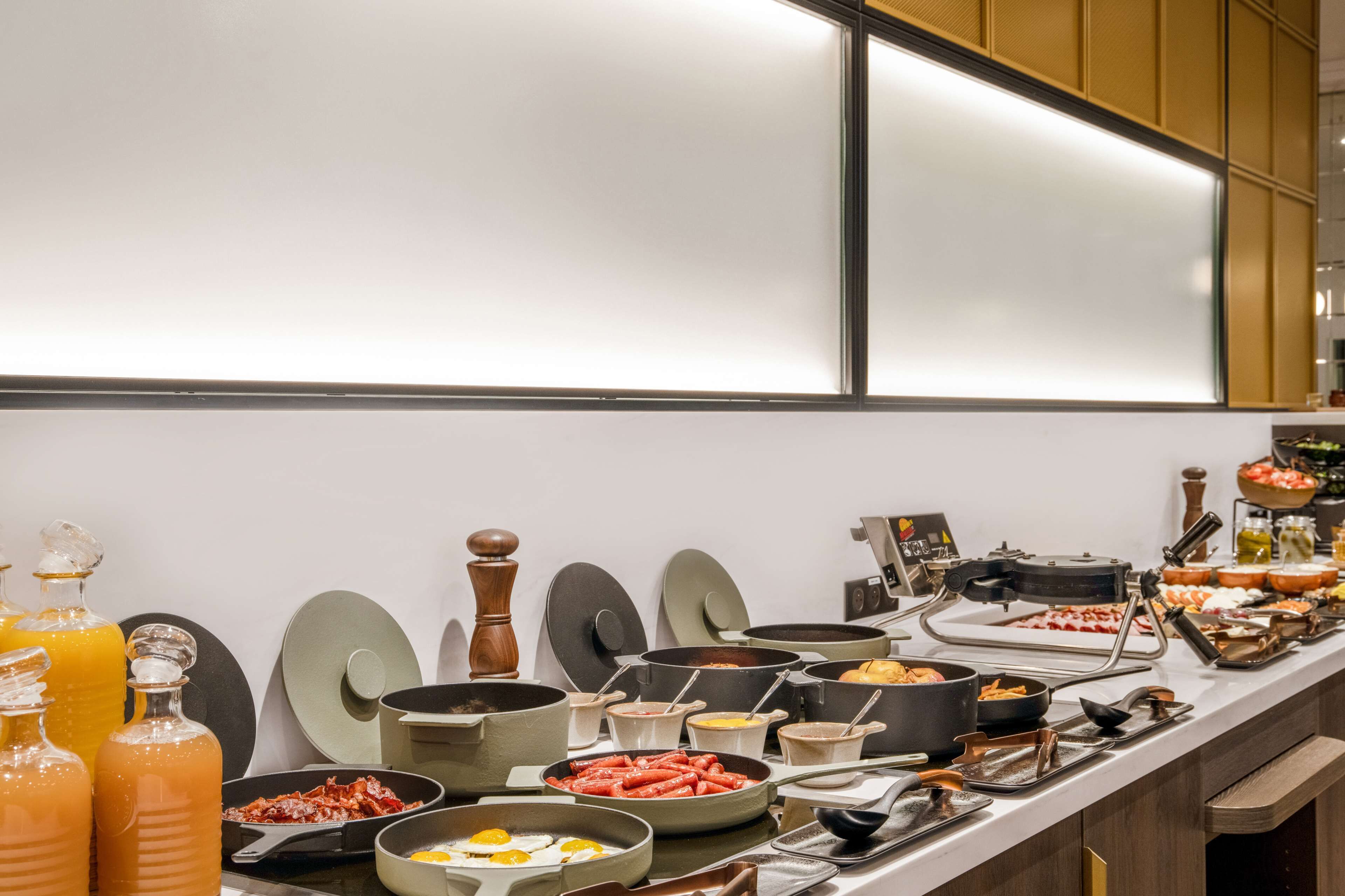 A buffet with various food items and cooking equipment.