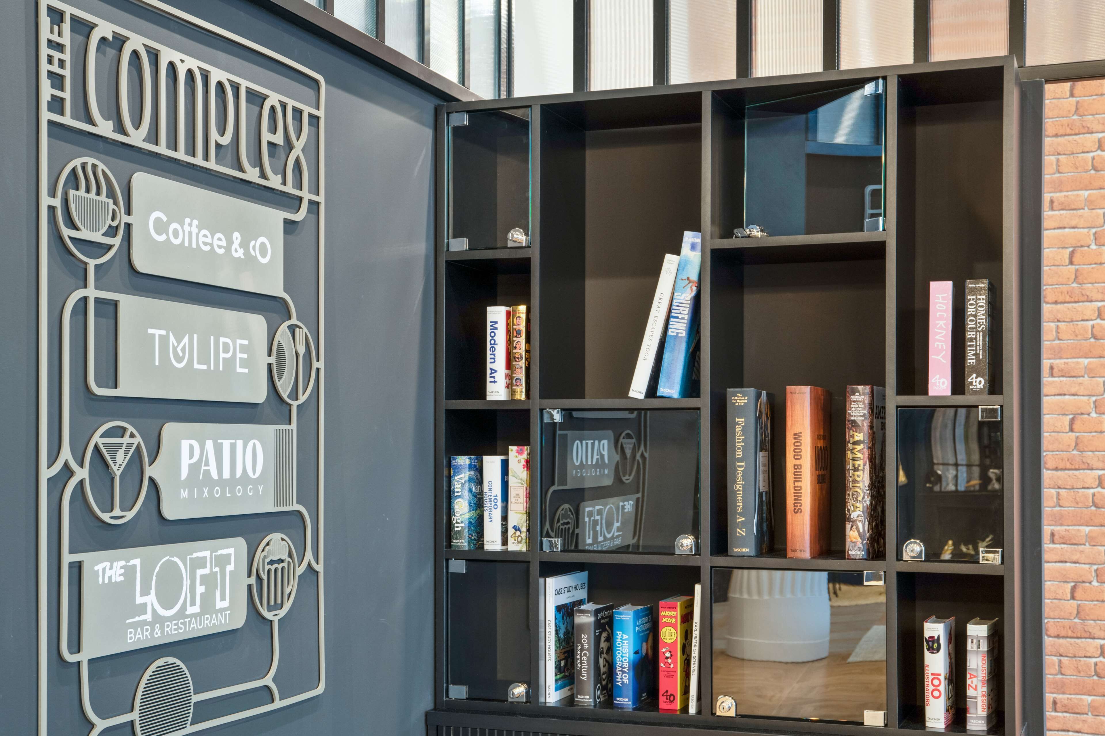 A section of a library with bookshelves, a coffee and cocktail bar, and a patio area.